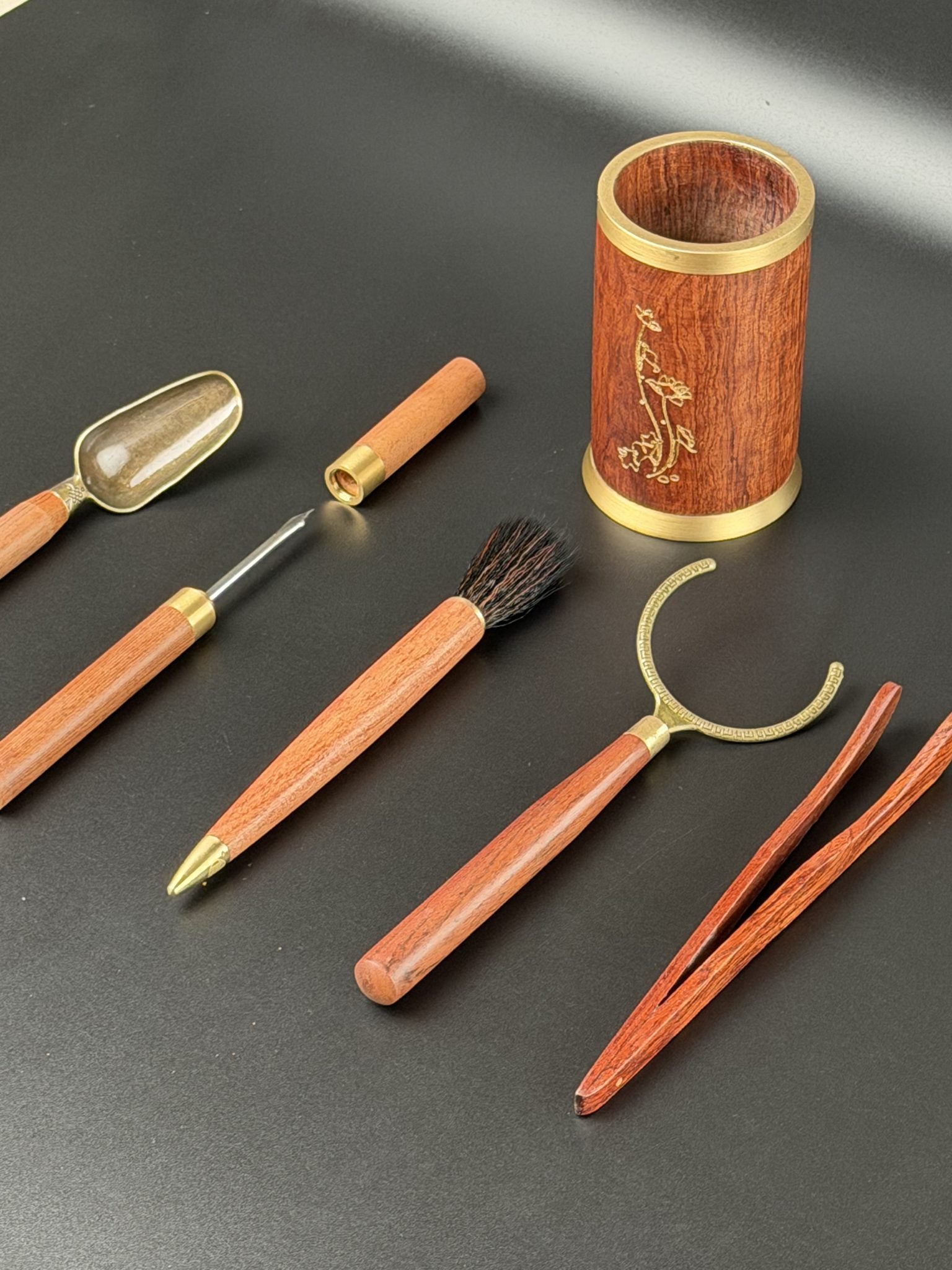Ustensiles de gong fu cha Daothé en bois et laiton disposés autour de leur pot gravé