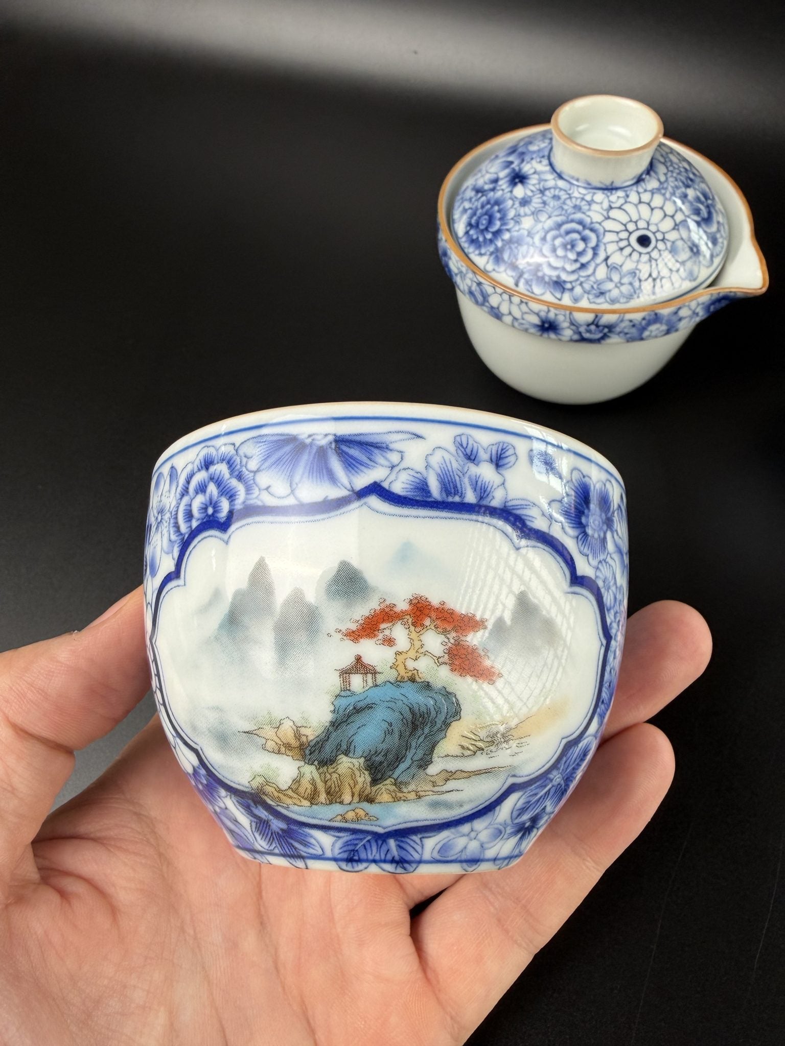 Vue de dessus de la théière de voyage Daothé, couvercle à décor floral bleu et deux tasses