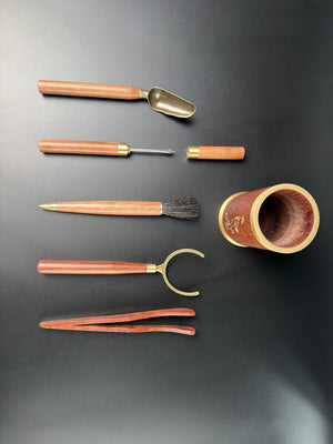 Les ustensiles à thé Daothé à plat : pot, doseur, couteau à thé, pinceau, pince en laiton et brucelles en bois